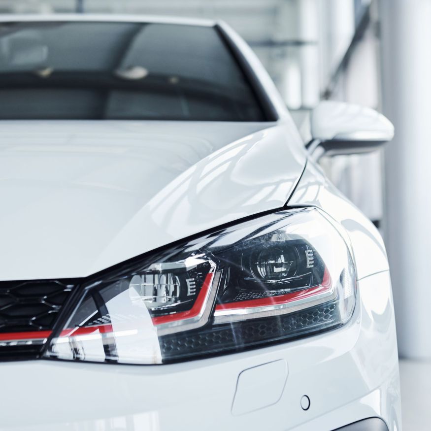 Close up view of brand new white colored polished automobile.